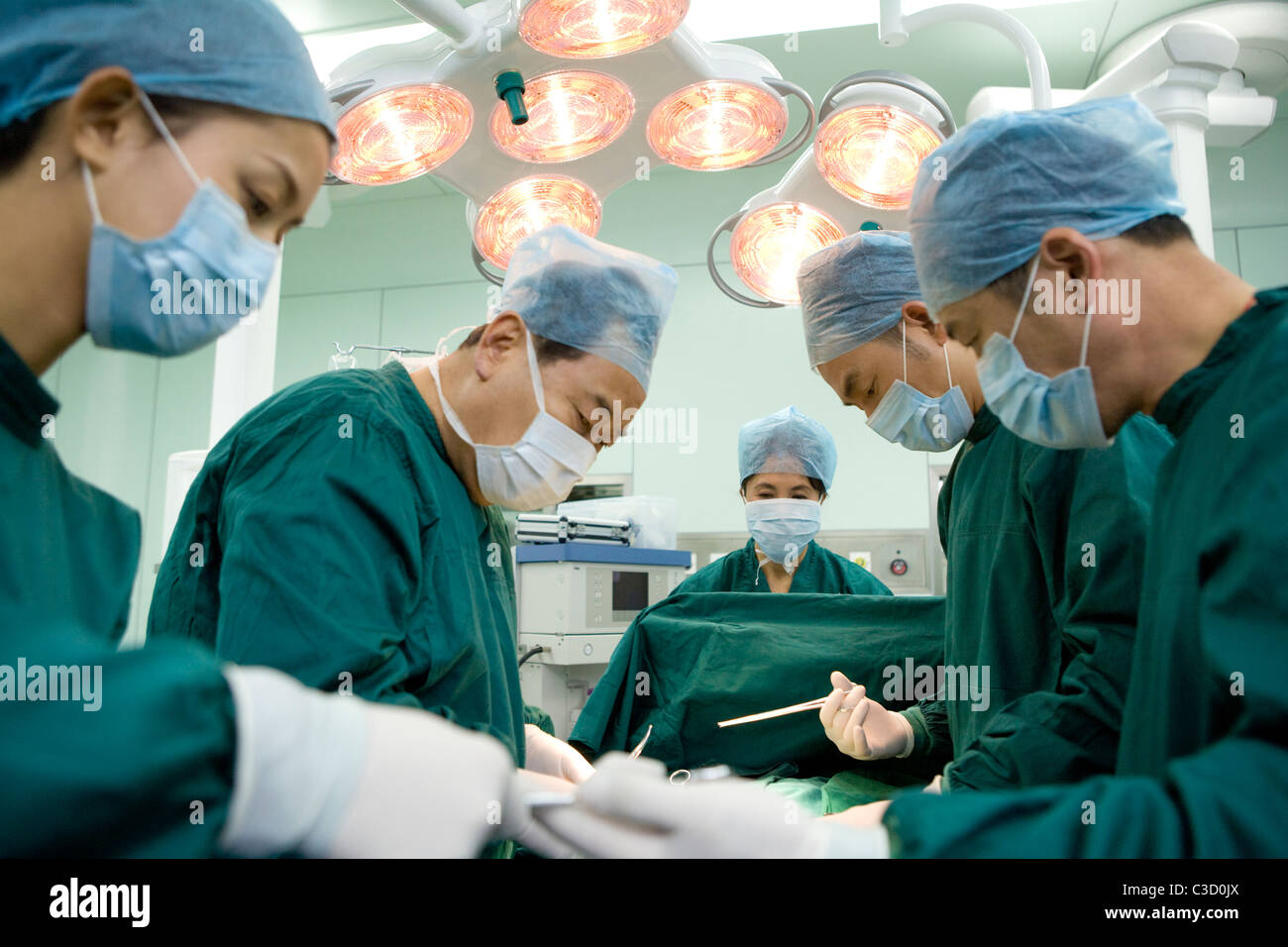 Équipe de chirurgiens travaillant dans une salle d'opération Banque D'Images