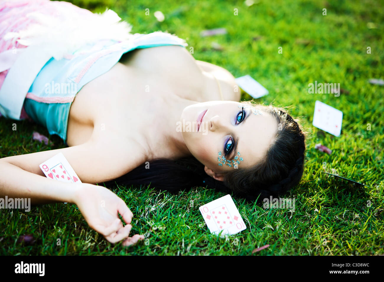 Jeune femme mystérieuse avec les cartes dans l'herbe autour de Banque D'Images