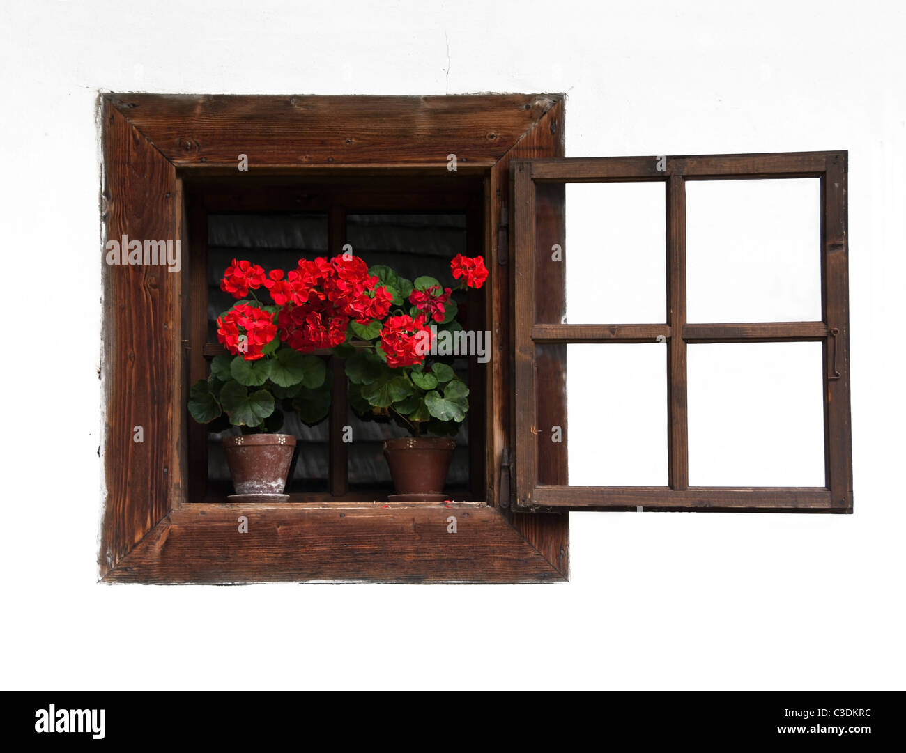 Ouvre la fenêtre traditionnelle en bois avec des fleurs rouge sur Mur Blanc Banque D'Images