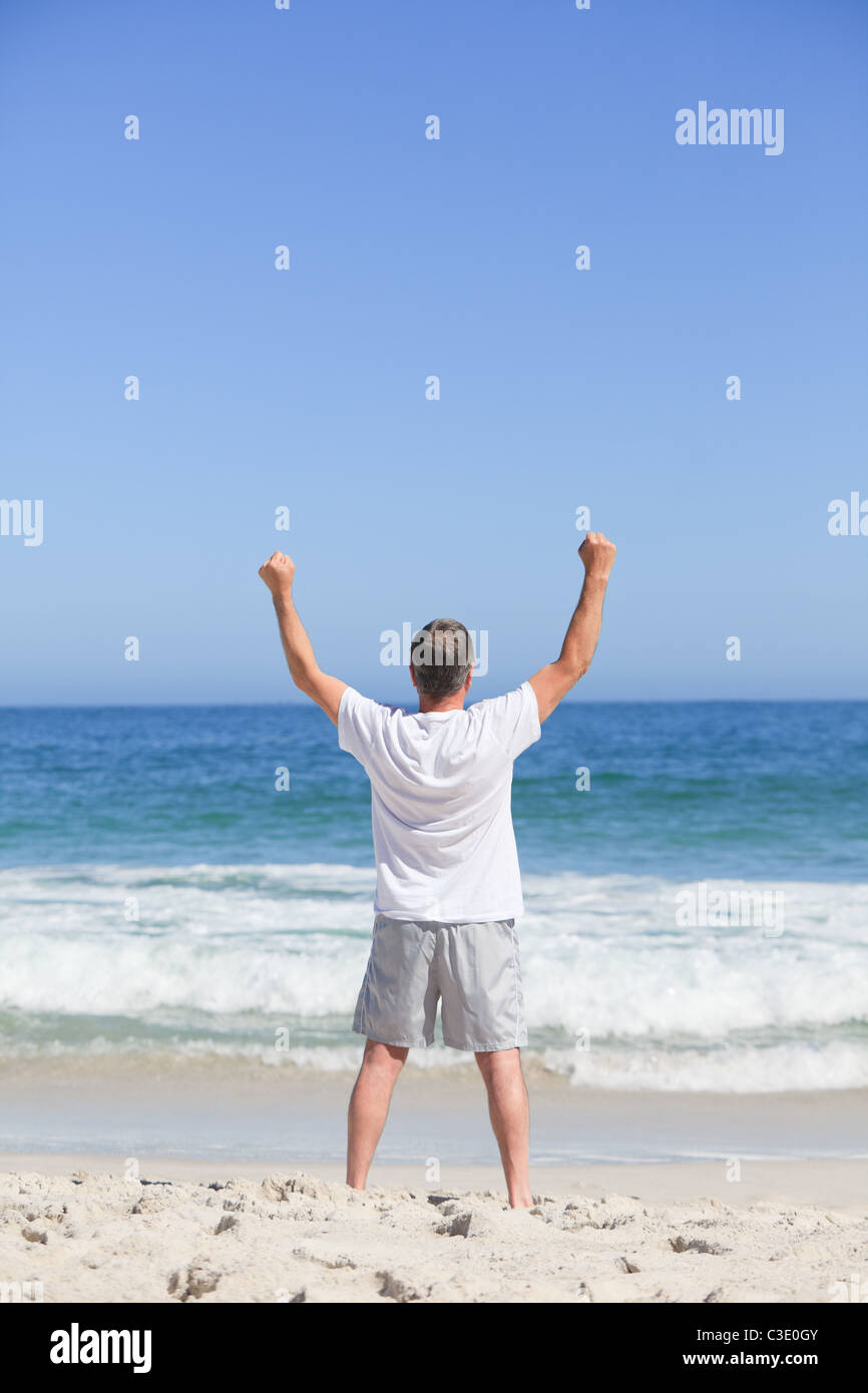 L'homme faisant son s'étend sur la plage Banque D'Images