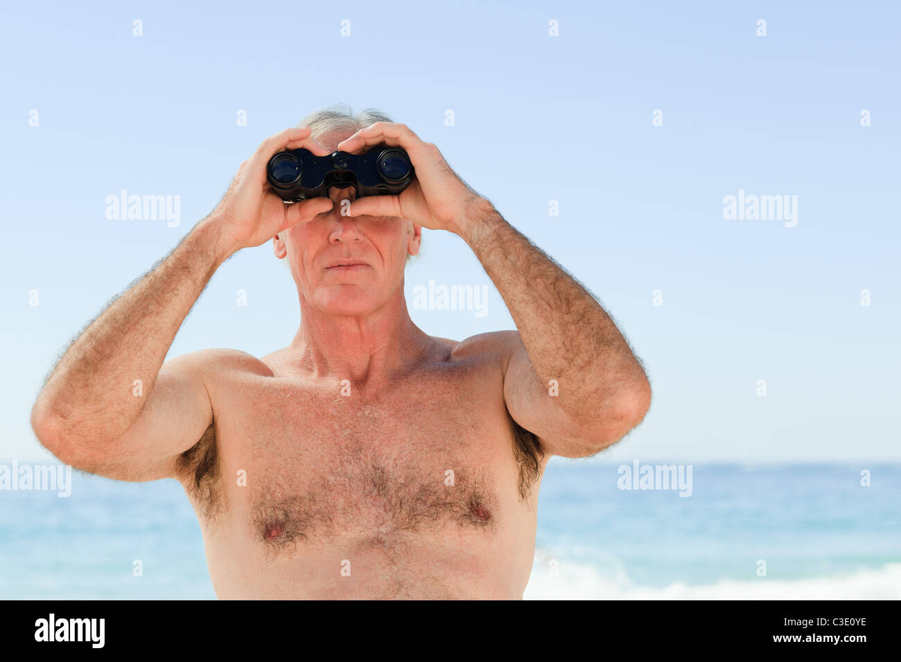 Man l'observation des oiseaux à la plage Banque D'Images