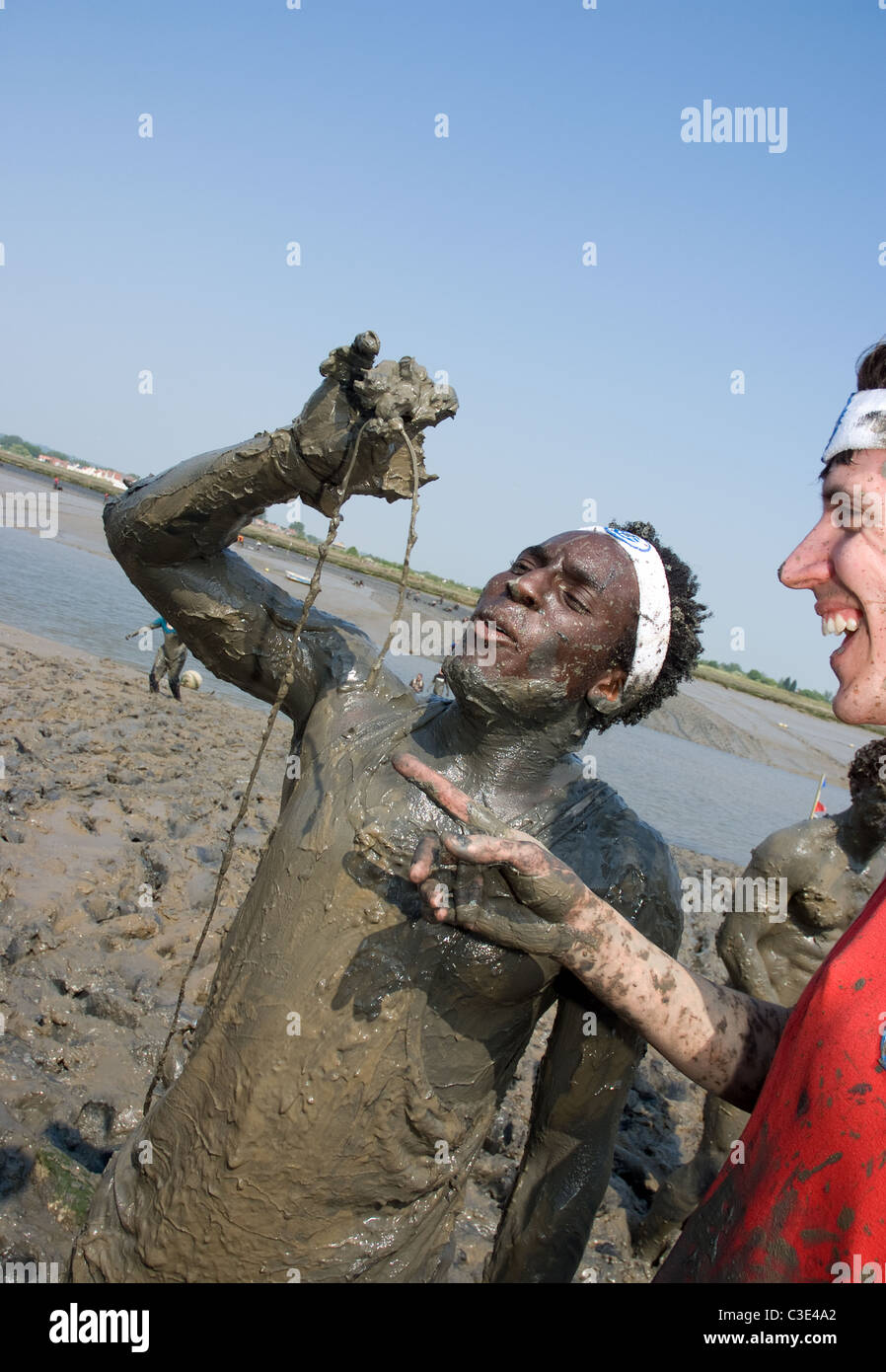 Blue Peter presenter Andy Akinwolere extrait ses microphone cassé après avoir pris part à la course de boue Maldon 2011 Banque D'Images