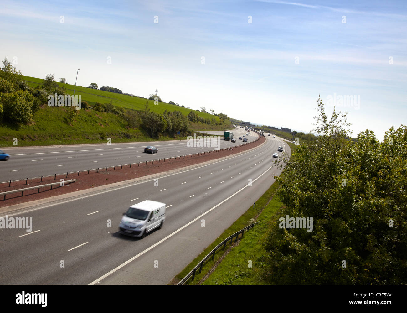 L'autoroute M1 en Angleterre. Tourné sur journée ensoleillée avec ciel bleu. Montrant six voies de la chaussée. Dans la courbe de la route. Cadre rural. Banque D'Images