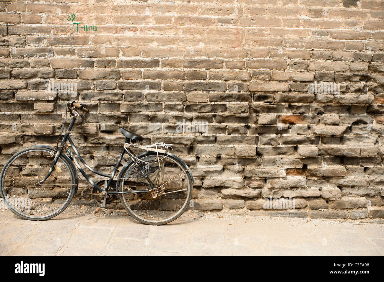 Vieux vélo contre les intempéries brick wall Banque D'Images