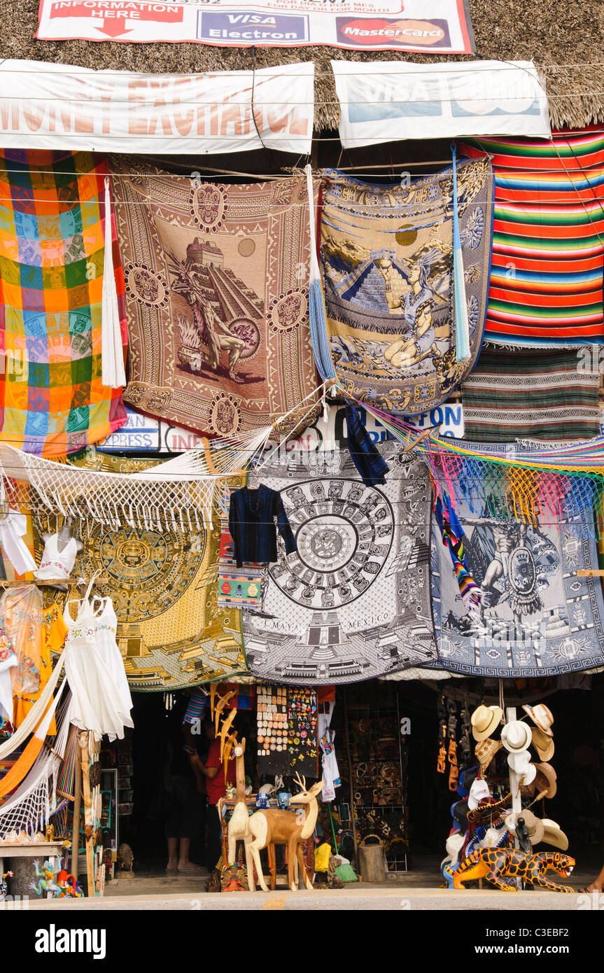 Boutique touristique Mayan souvenirs Coba Mexique // COBA, Mexique — Une boutique touristique vend des textiles et des souvenirs d'inspiration maya dans le parking du site archéologique de Coba sur la péninsule du Yucatan au Mexique. Coba est un vaste complexe archéologique maya situé à environ 44 kilomètres (27 miles) au nord-ouest des ruines côtières de Tulum. L'ancienne ville est située entre deux lacs, Coba et Macanxoc, dans la jungle de l'état de Quintana Roo. Les preuves archéologiques suggèrent que Coba a été habitée à partir de 100 EC et a atteint son apogée entre 200-900 EC, quand on estime qu'il a supporté une popul Banque D'Images