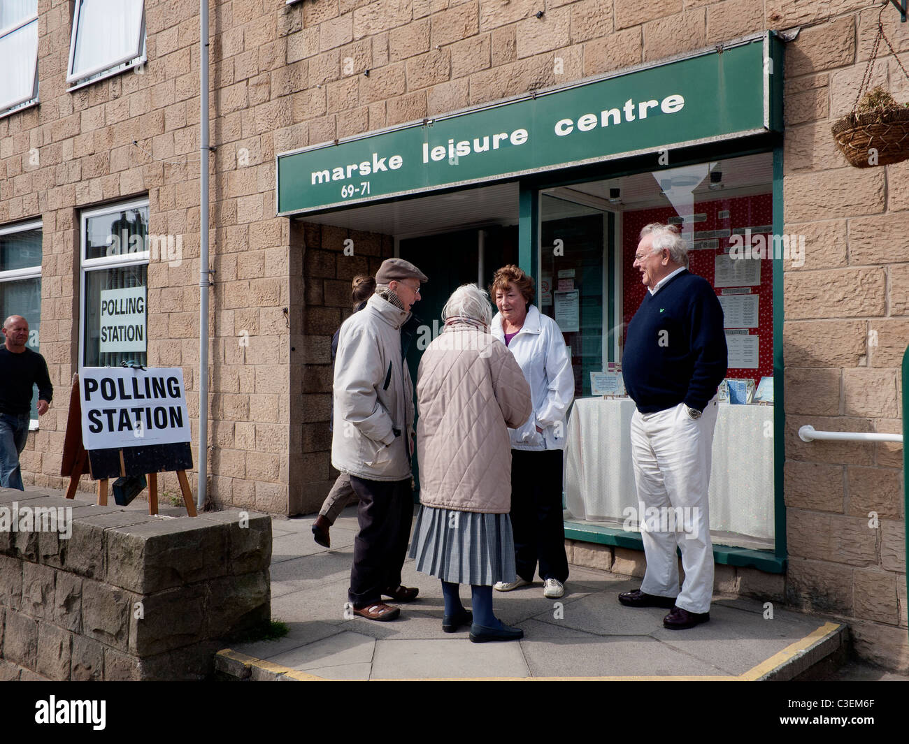 Les gens discuter des élections locales à l'extérieur d'un bureau de vote chargé Banque D'Images