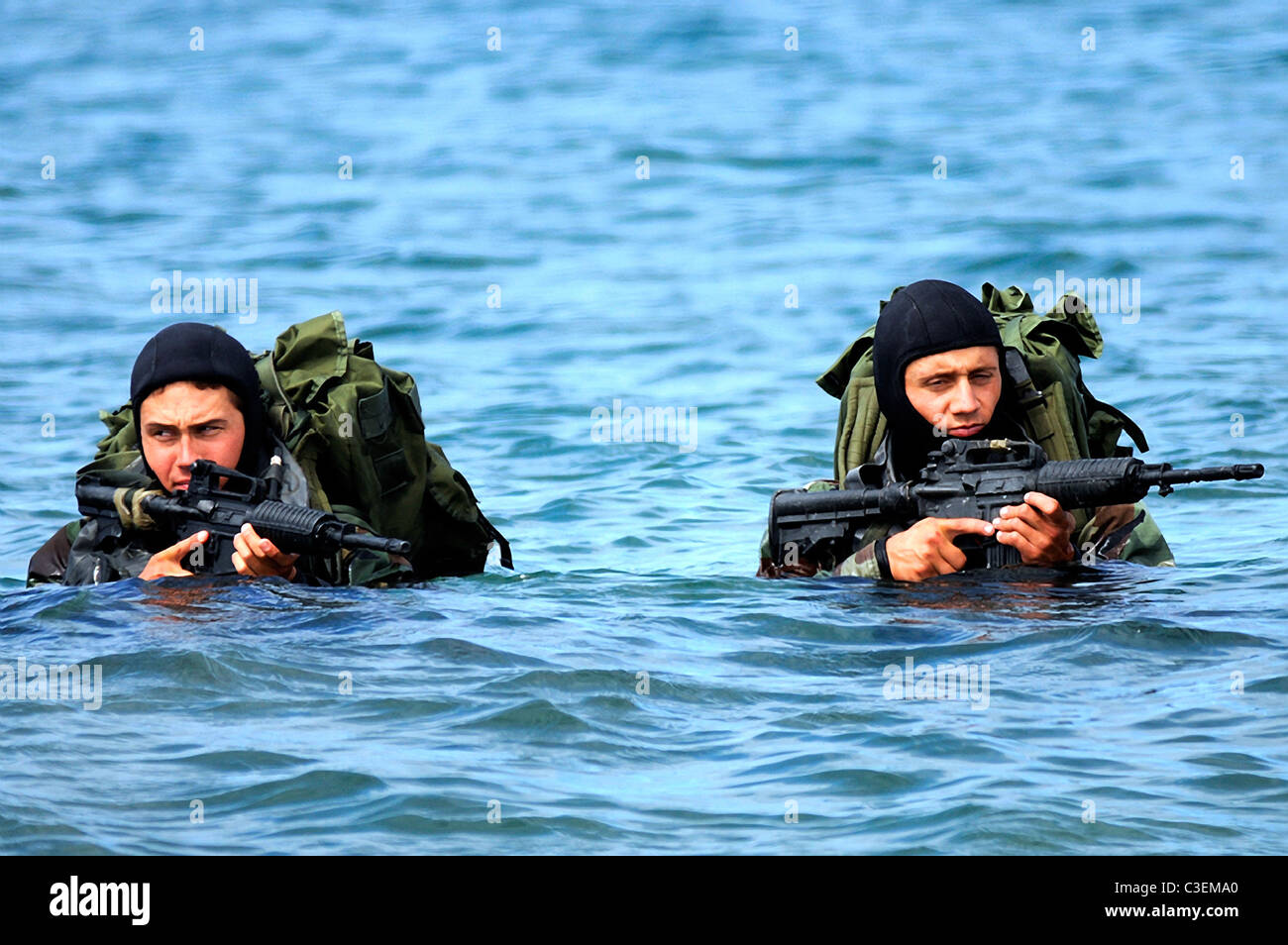 Les membres de l'équipe de l'US Navy SEAL Wade à terre sur l'île San Clemente au cours d'un exercice sur la plage. Banque D'Images