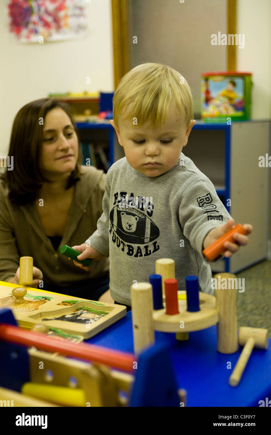 L'école maternelle enfant développe la coordination œil main en jouant avec des jouets de type casse-tête. Banque D'Images