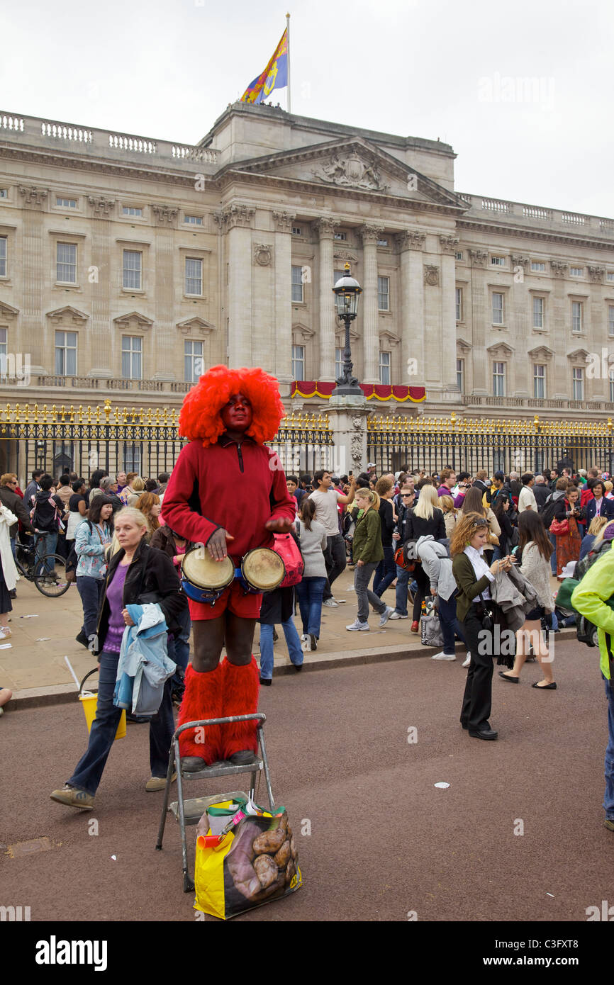 Un homme à l'extérieur de Buckingham Palace pour le mariage royal de prince William et Kate Middleton jouant les bongos, Londres Banque D'Images