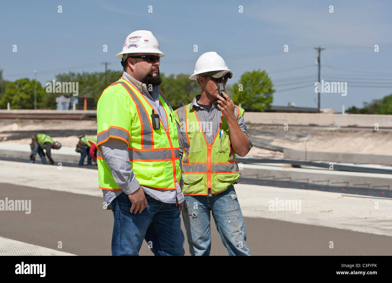 White male construction workers le long tronçon de route nouvelle construction à Austin, Texas Banque D'Images