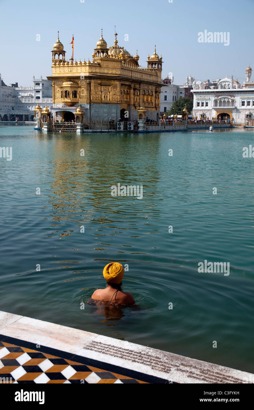 Un Sikh se baigner dans l'étang du Temple d'or d'Amritsar, en Inde. Banque D'Images