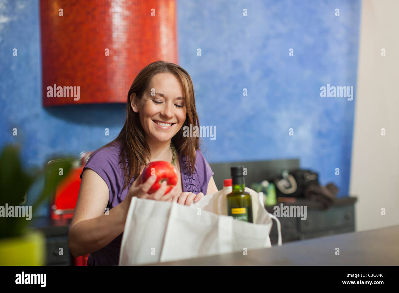 Femmes enceintes Caucasian woman unpacking groceries in kitchen Banque D'Images