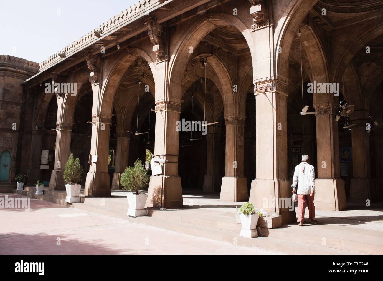 Homme marchant dans une mosquée, la Mosquée Siddi Sayed, Ahmedabad, Gujarat, Inde Banque D'Images