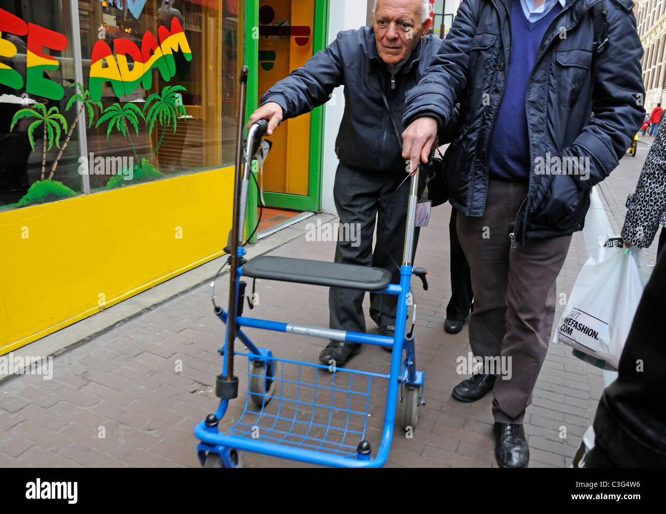 Amsterdam, Pays-Bas. Vieil homme marcher avec l'aide de châssis à roues chariot de marche / Banque D'Images
