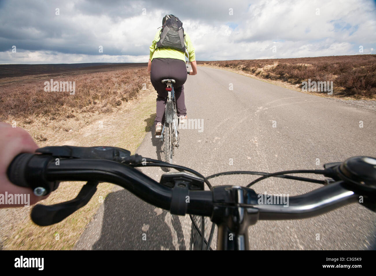 Une femme vtt sur la route de North York Moors Hutton-le-Hole à Rosedale. Banque D'Images