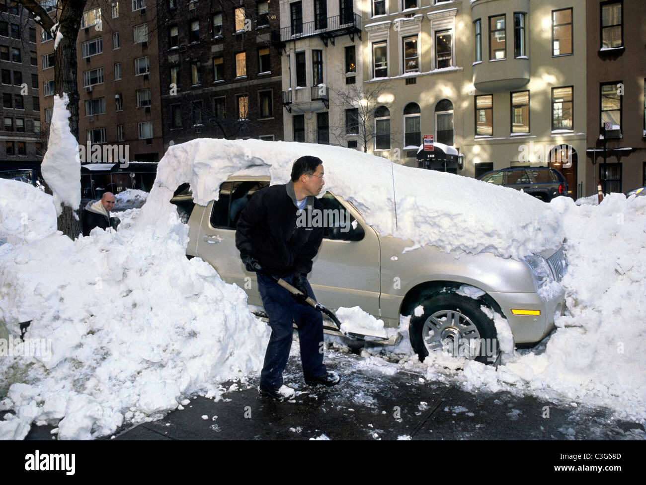 L'homme de sous Location de pelleter la neige profonde On City Street Banque D'Images