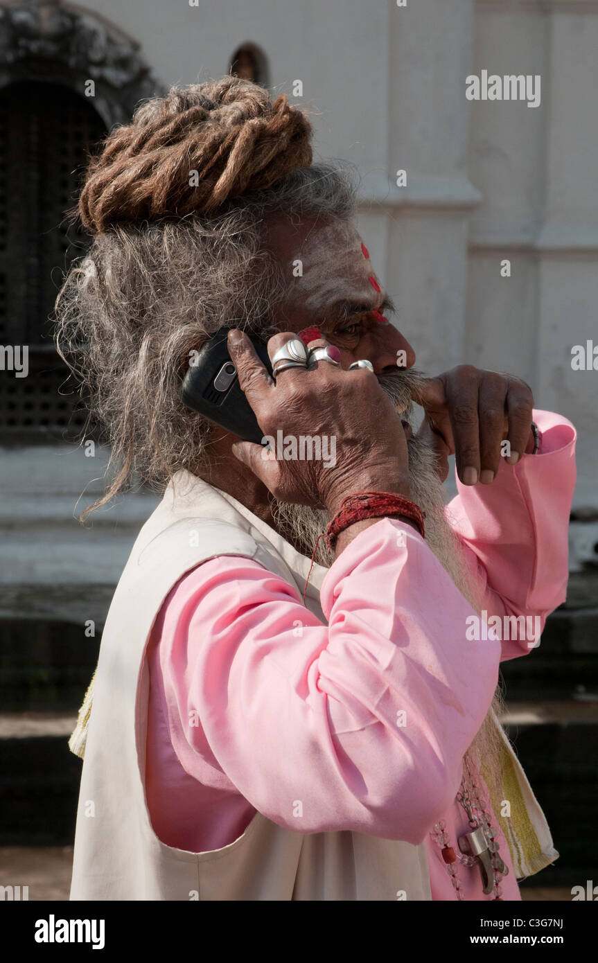 Un sadhu en utilisant un téléphone mobile au temple de Pashupatinath, Katmandou Banque D'Images
