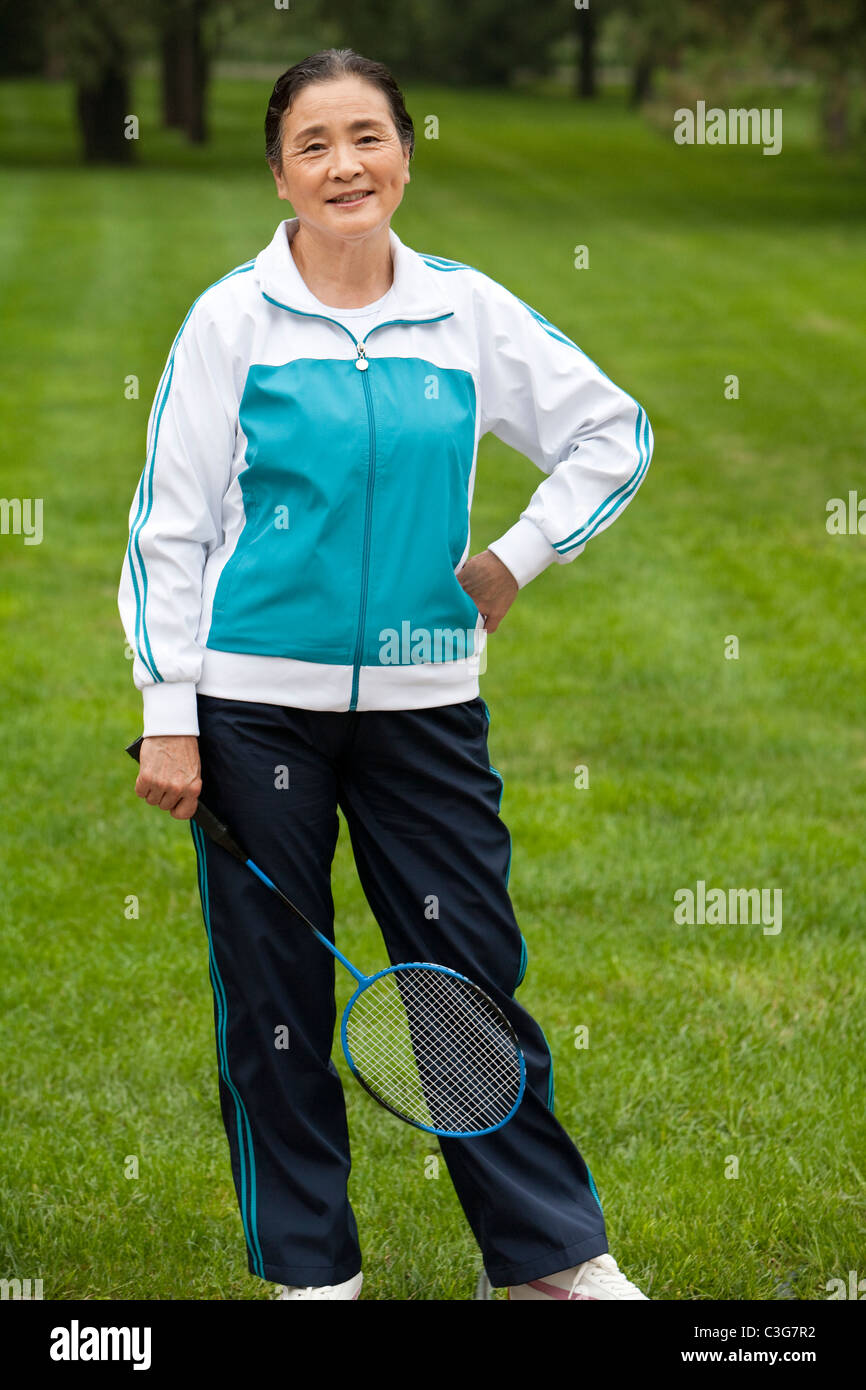 Senior Woman Holding Badminton Racket dans un parc Banque D'Images