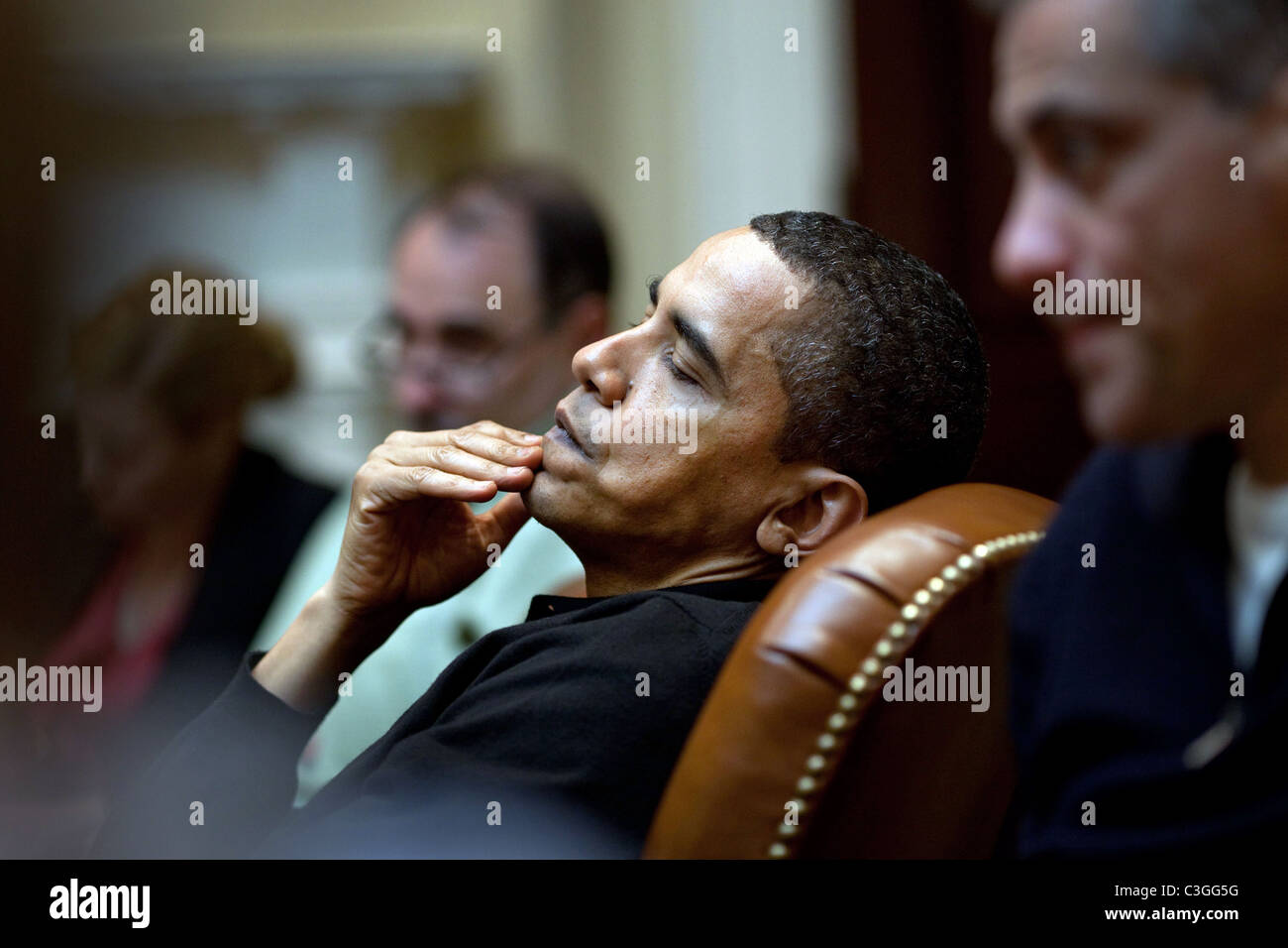 Le président Obama reflète au cours d'une réunion avec les conseillers économiques dans la Roosevelt Room. Il est assis entre Senior Advisor Banque D'Images