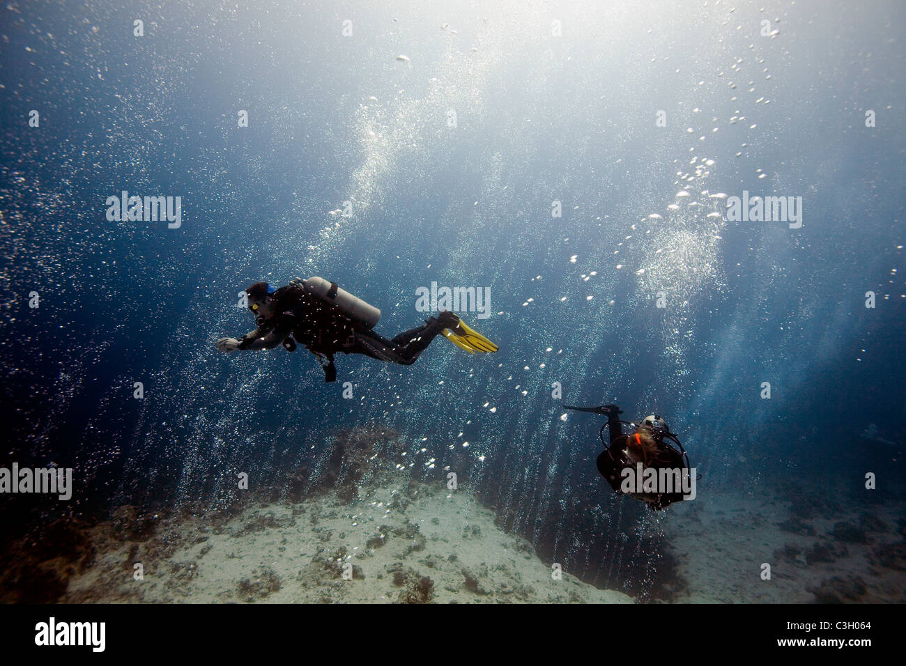 Deux plongeurs nagent dans le flux de bulles s'élevant du Canyon. Mer Rouge, Dahab, Egypte Banque D'Images