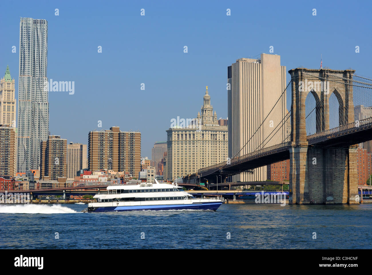 Un bateau de croisière sur l'East River titre sous le pont de Brooklyn à New York. Banque D'Images