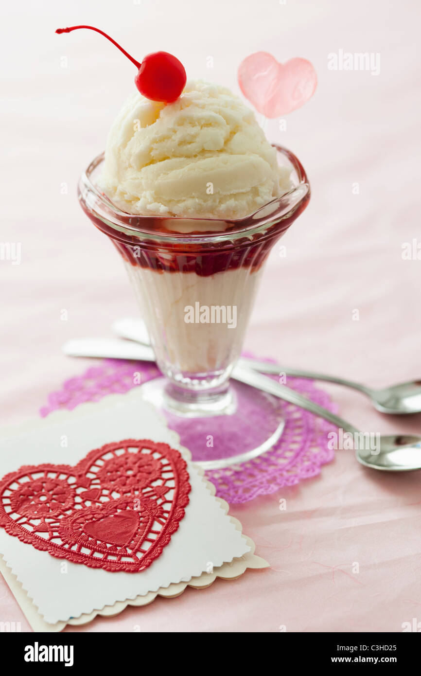 Close up of ice cream dessert avec cerise sur le dessus et découpe en forme de coeur Banque D'Images