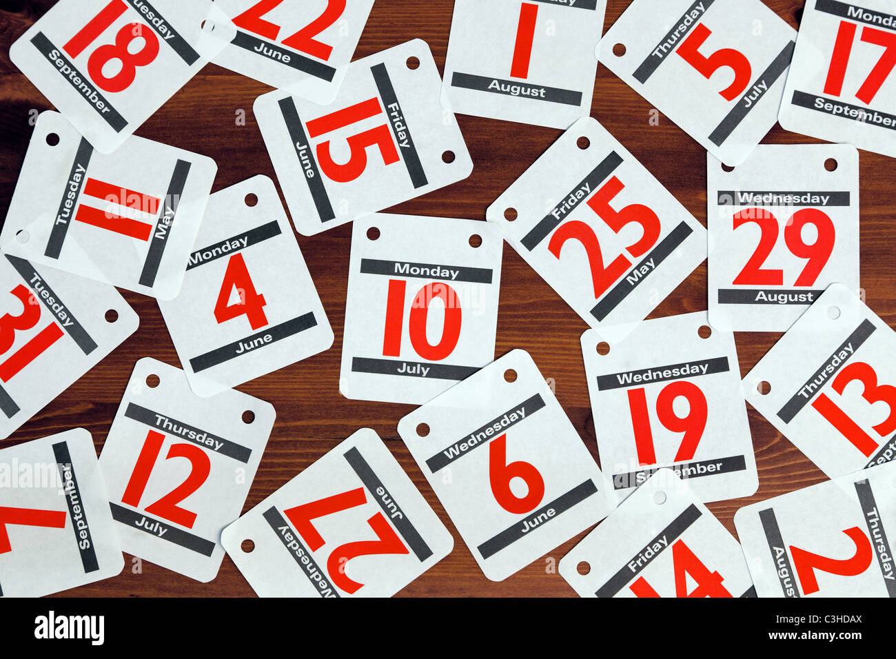 Photo de différentes dates de calendrier étalé sur un bureau en bois. Banque D'Images