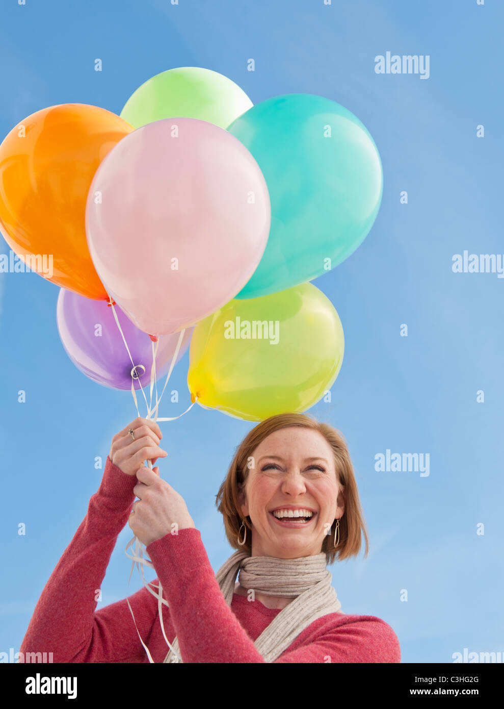 Woman holding bunch of balloons Banque D'Images