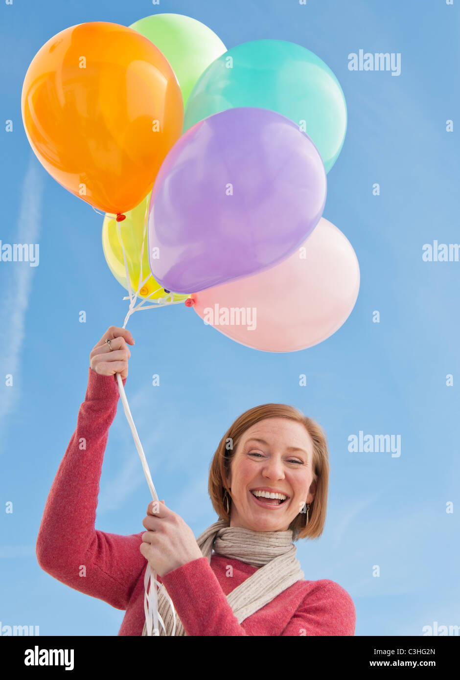 Woman holding bunch of balloons Banque D'Images