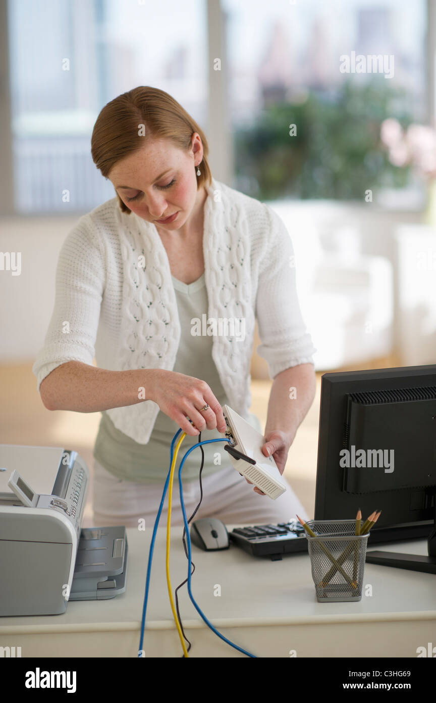 Femme d'installer un routeur à home office Banque D'Images