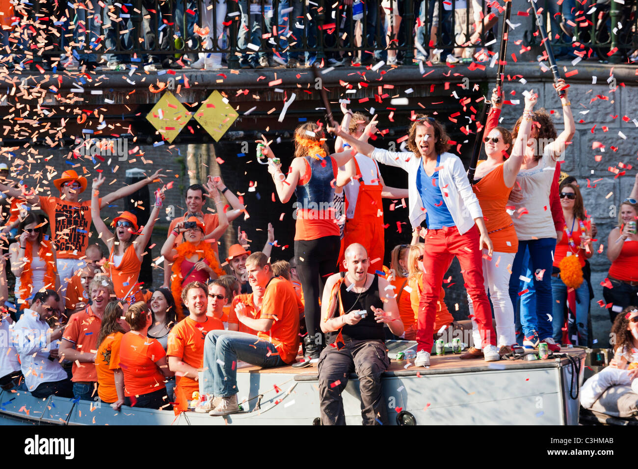 La fête du Roi, l'anniversaire du roi, autrefois le jour de la Reine. L'Amsterdam Canal Bateaux Parade fête confetti orange gens tir. Banque D'Images