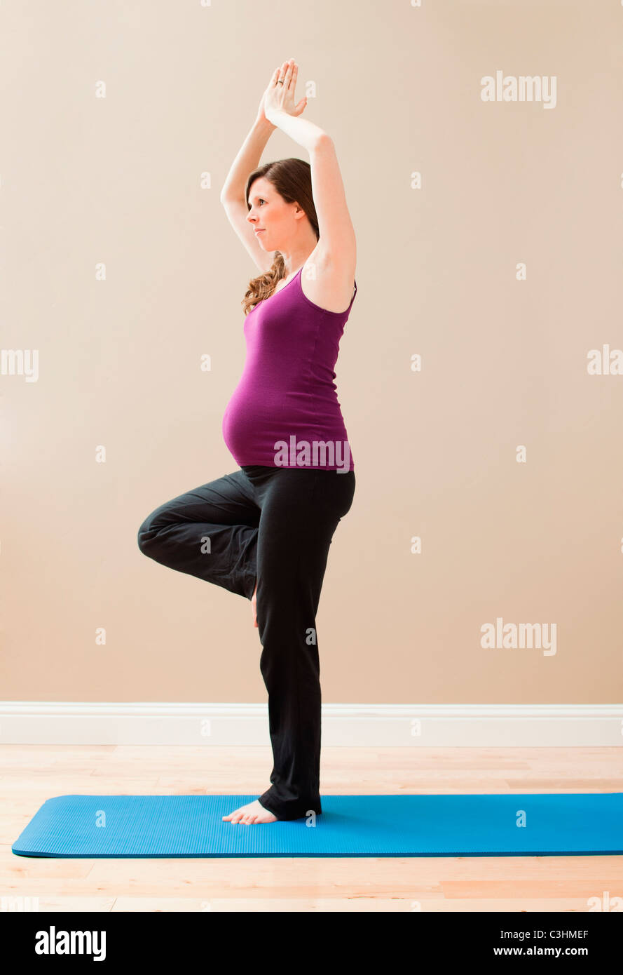 Jeune femme enceinte l'exercice, debout sur une jambe Banque D'Images