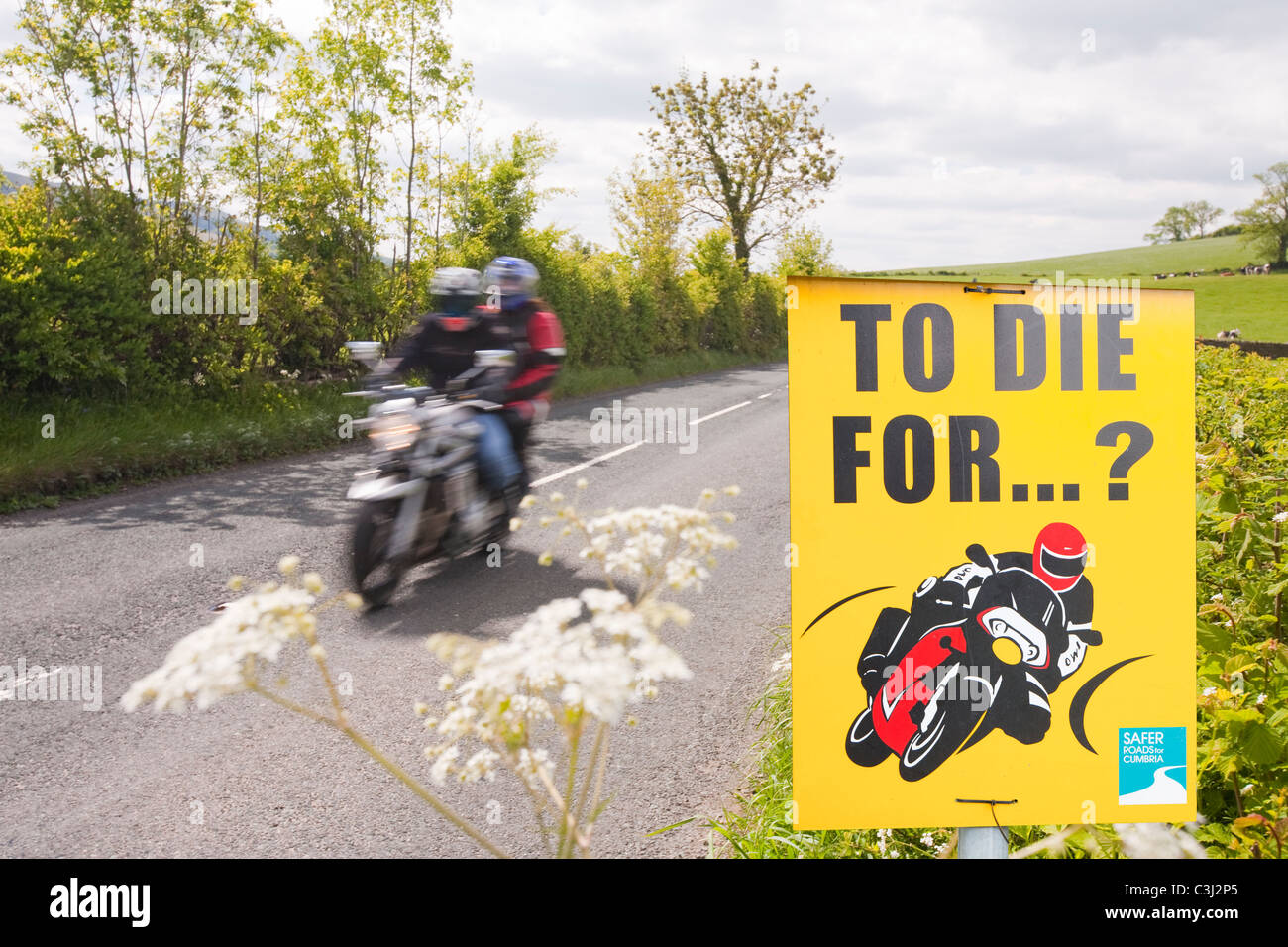 Les cyclistes sur une route de campagne près de Kirkby Lonsdale, Cumbria, Royaume-Uni, avec un ralentissement de la police signe. Banque D'Images