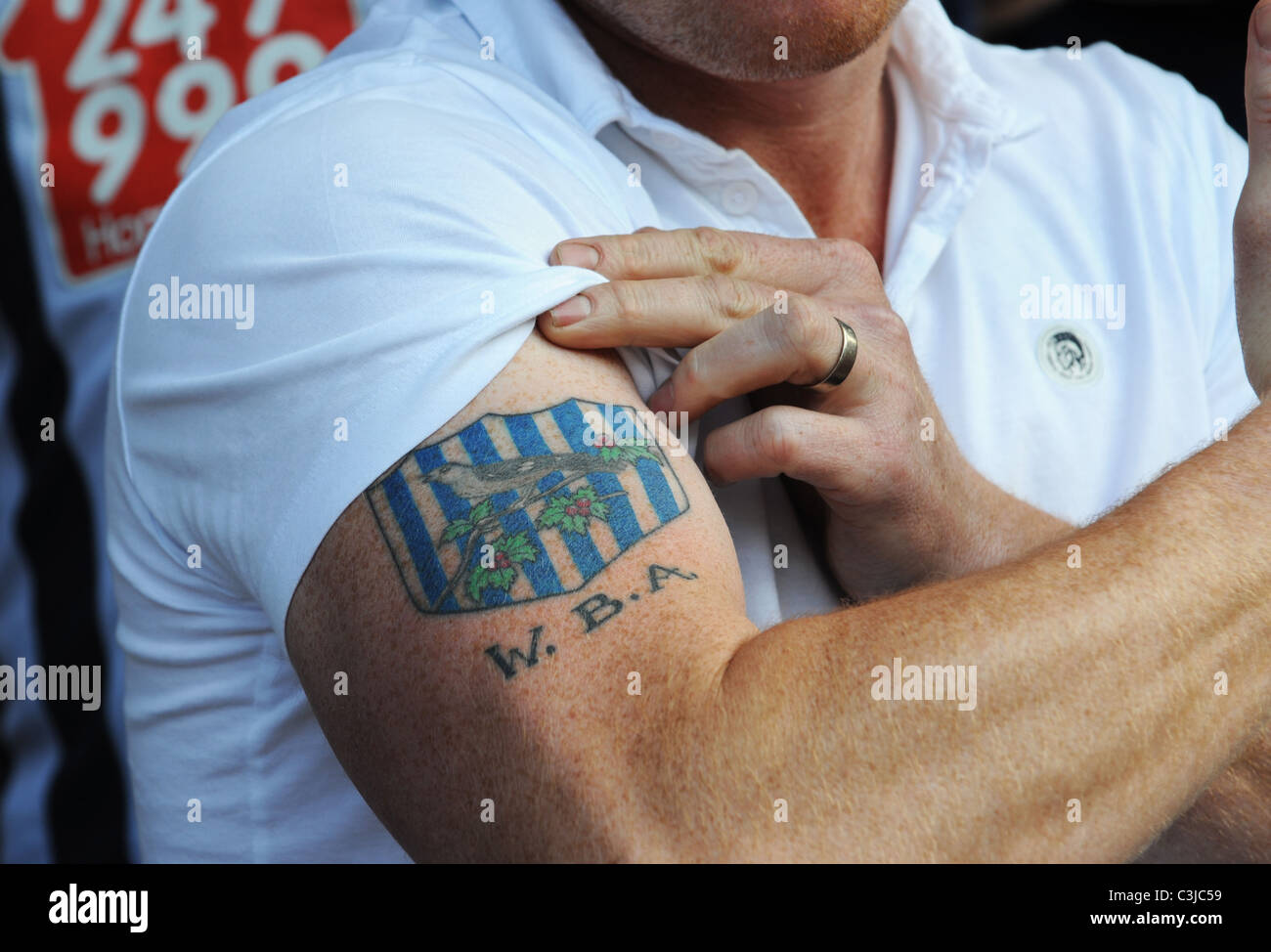 Supporter de football montrant son badge club tattoo Banque D'Images