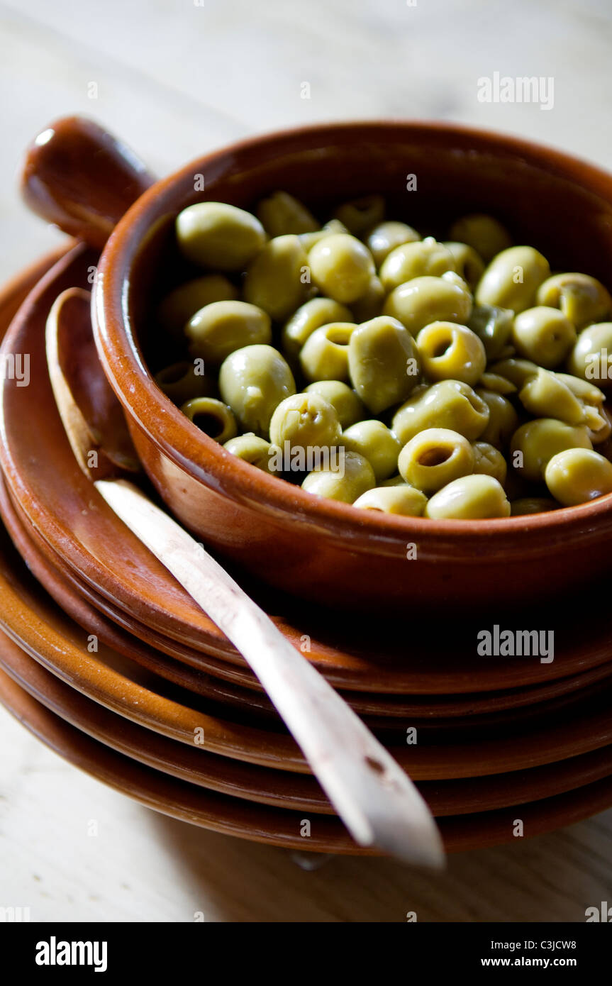 Les olives dans une casserole en terre cuite sur une pile de plaques en terre cuite Banque D'Images