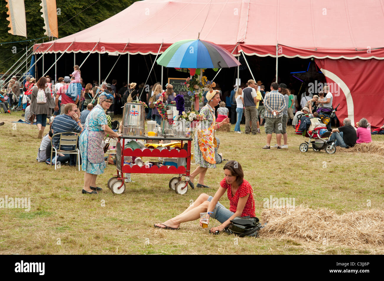 Une femme est assise sur l'herbe, devant le chapiteau tente au Port Eliot Literary Festival St allemands Cornwall Banque D'Images