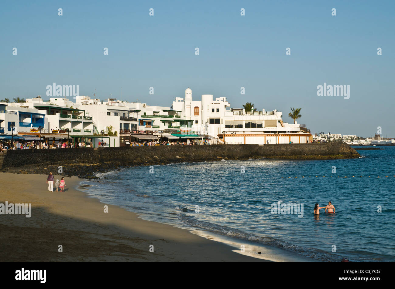 Dh Beach Playa Blanca Lanzarote Famille en vacances beach soirée tranquille promenade du front de mer Banque D'Images