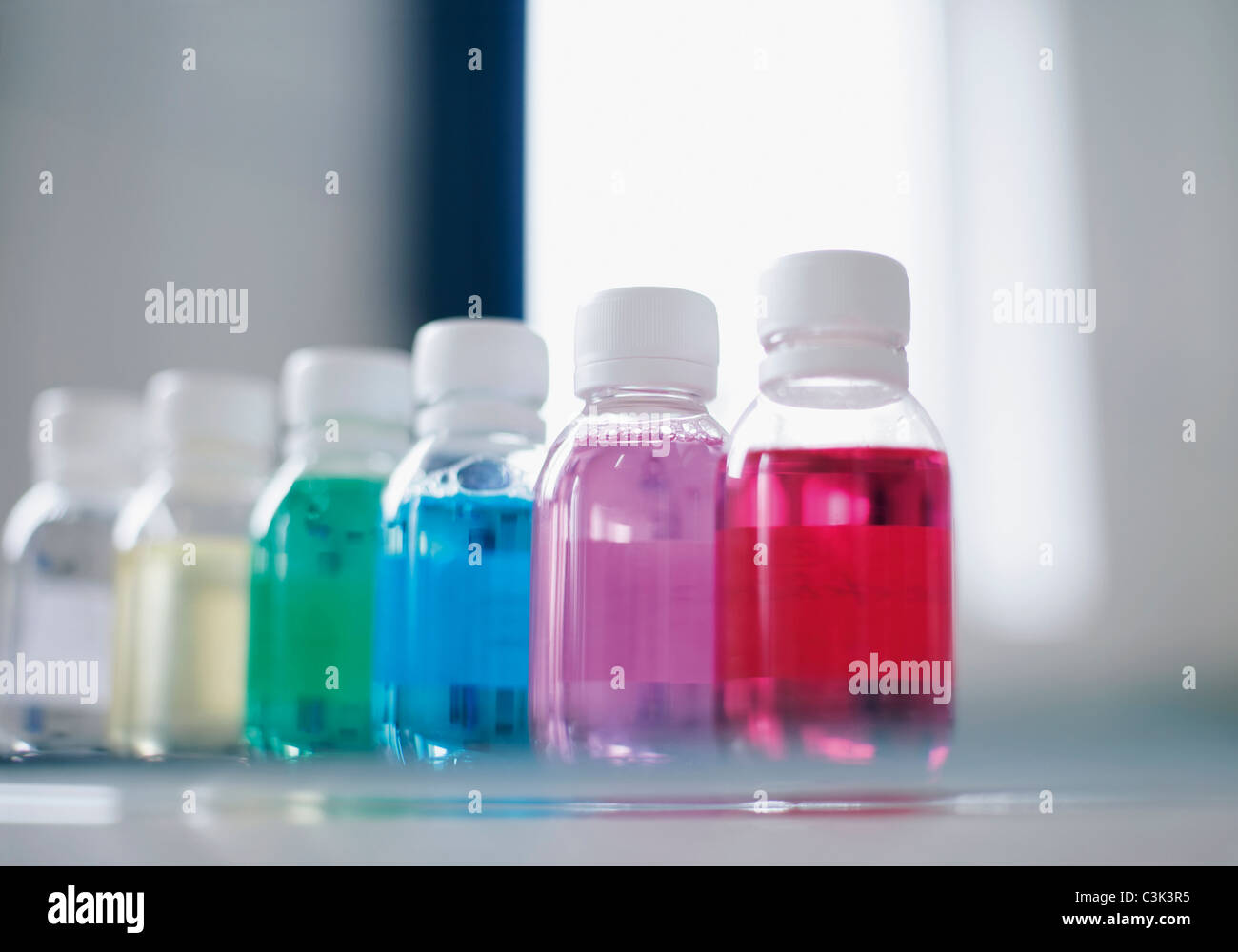 Rangée de bouteilles avec des liquides colorés, Close up Banque D'Images