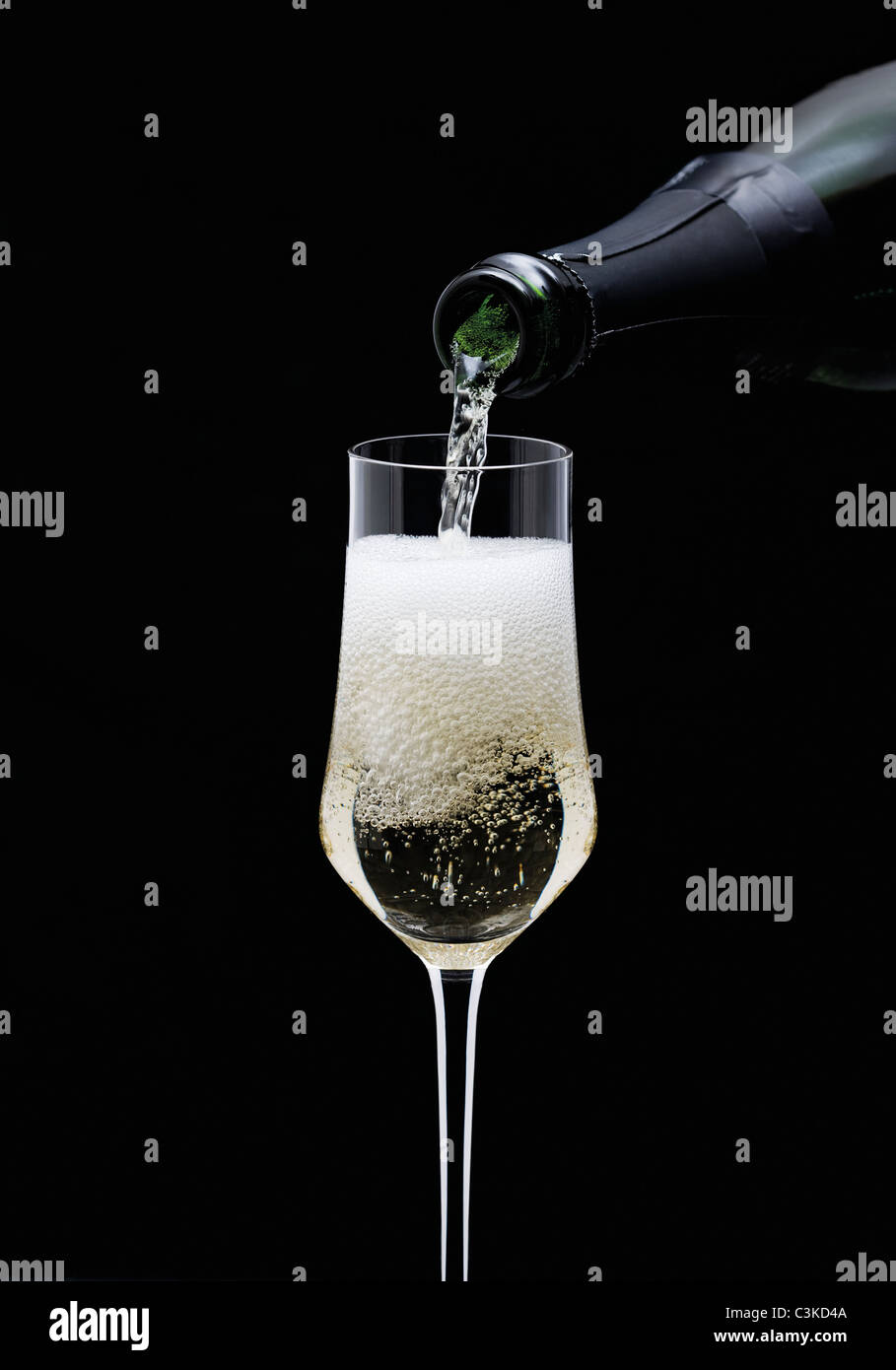 En Champagne et verser dans le verre de la bouteille, close-up Banque D'Images