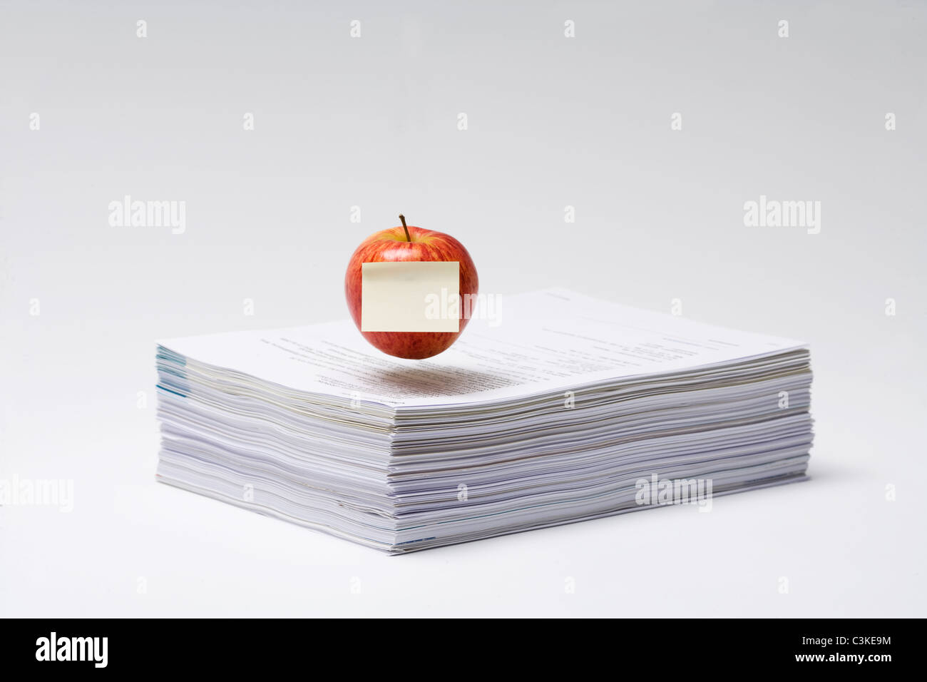 Une pomme sur une pile de papier, close-up. Banque D'Images