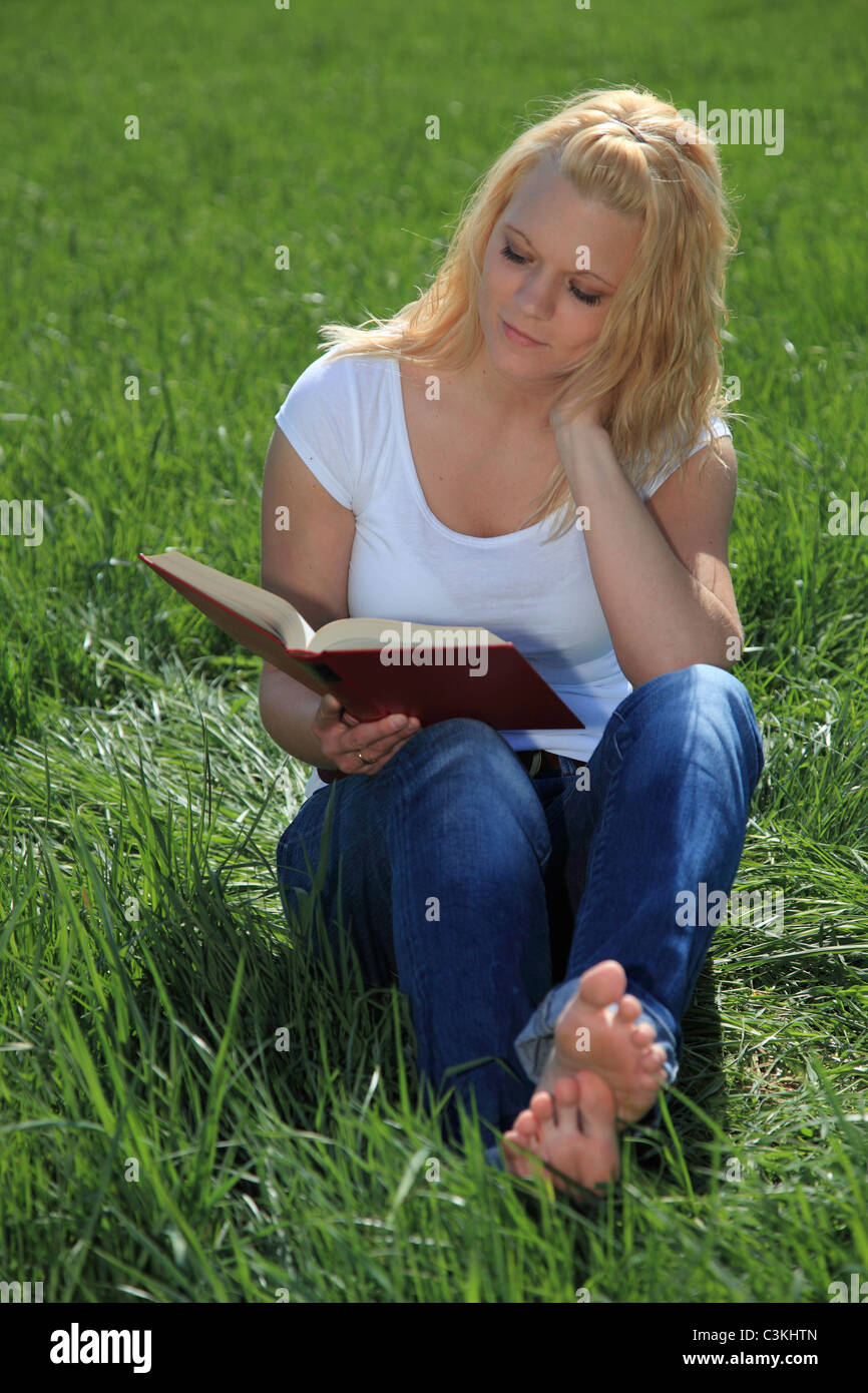 Jolie femme sur un pré vert la lecture d'un livre. Banque D'Images Jolie femme sur un pré vert la lecture d'un livre. Banque D'Images