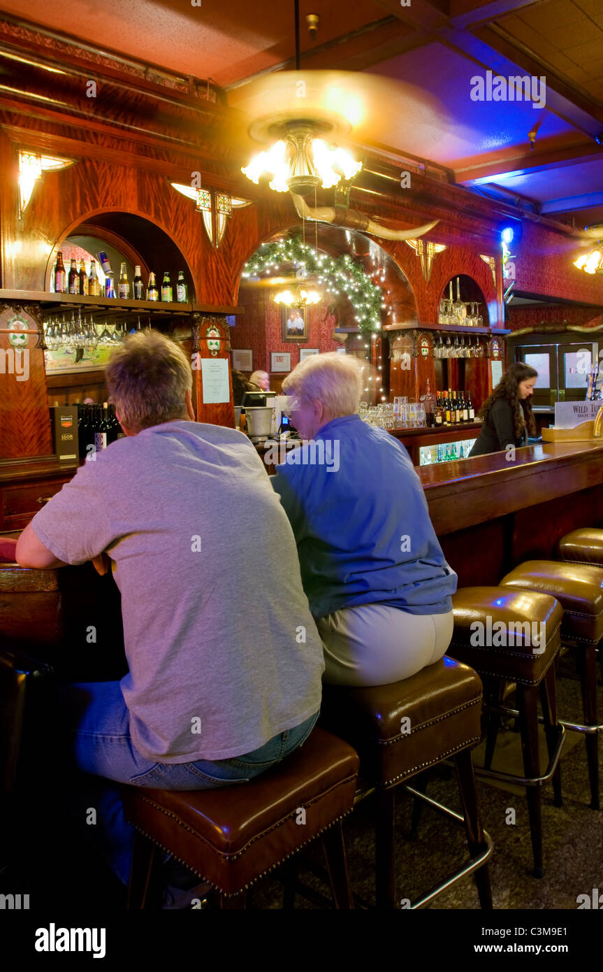 Clients assis au bar en bois ancien, l'extrême ouest de taverne, Guadalupe, Californie Banque D'Images