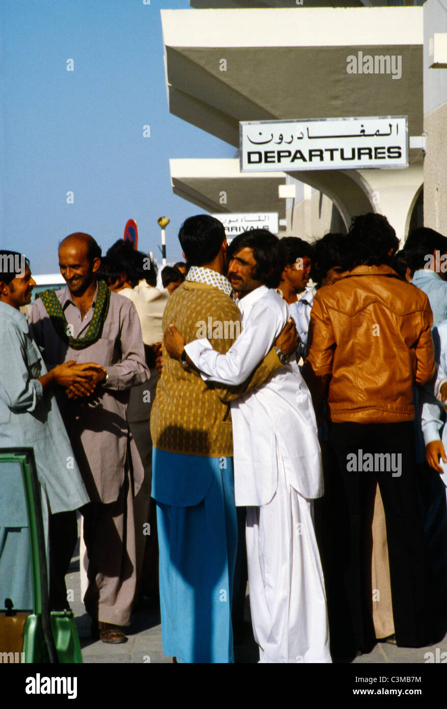 L'aéroport de Dubaï AUX ÉMIRATS ARABES UNIS Accueil Pakastani travailleurs invités par le baiser Embracing Banque D'Images