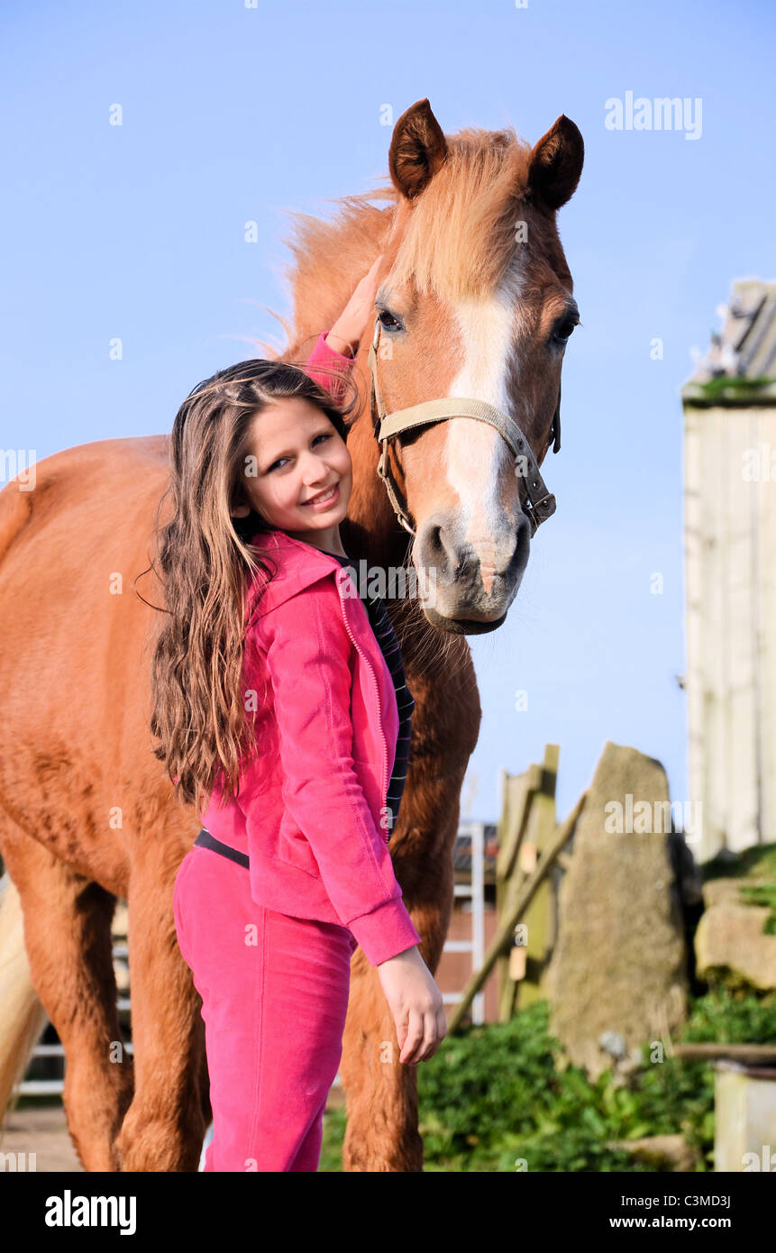 Poney alezan et jolie jeune fille en rose portrait Banque D'Images