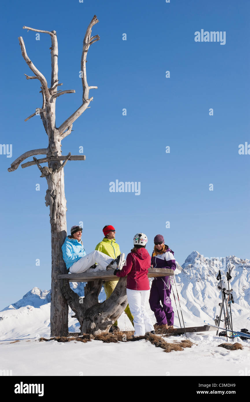 L'Italie, Trentin-Haut-Adige, Alto Adige, Bolzano, Alpe di Siusi, les gens se reposant près de l'arbre nu on snowy landscape Banque D'Images