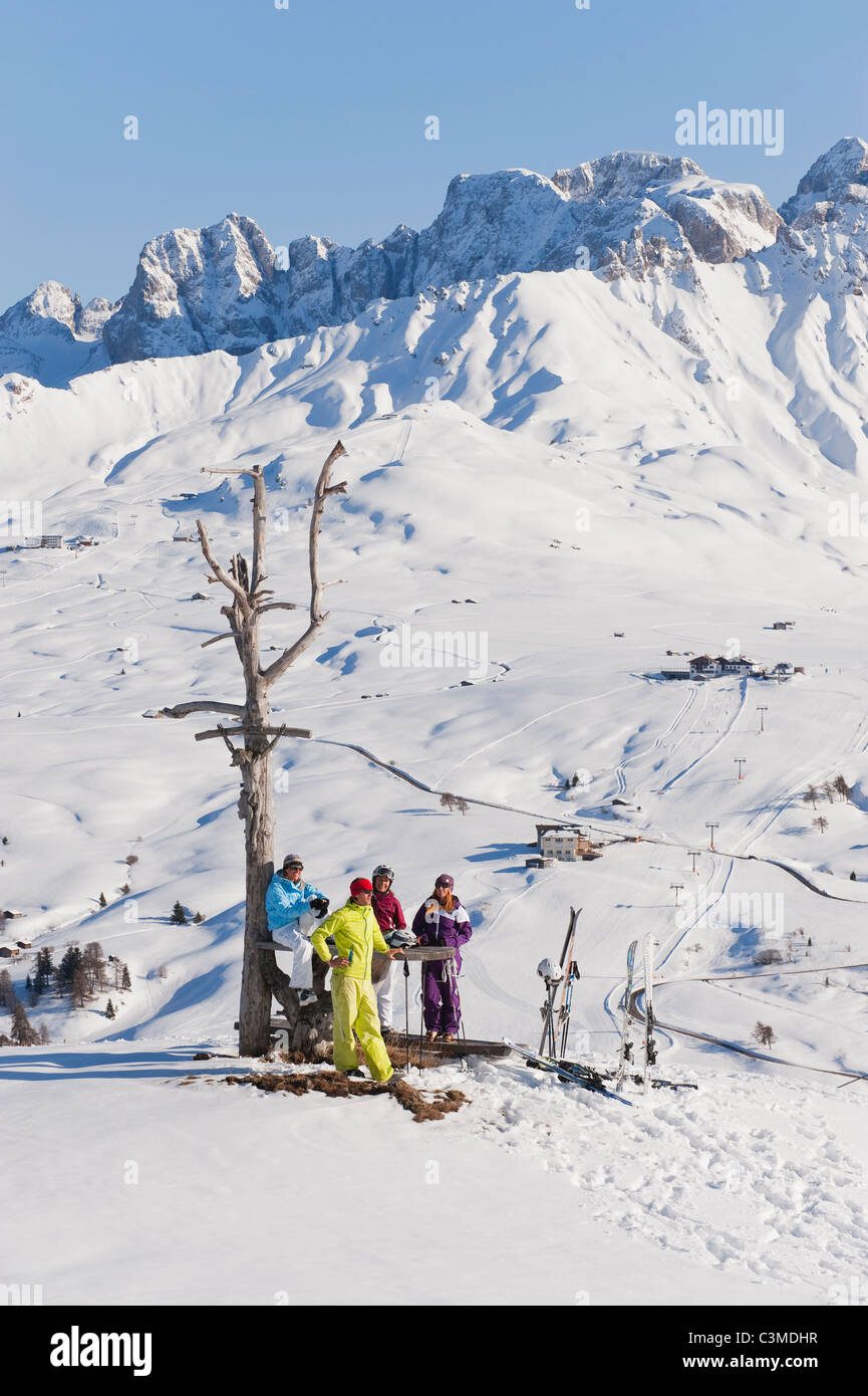 L'Italie, Trentin-Haut-Adige, Alto Adige, Bolzano, Alpe di Siusi, les gens se reposant près de l'arbre nu on snowy landscape Banque D'Images