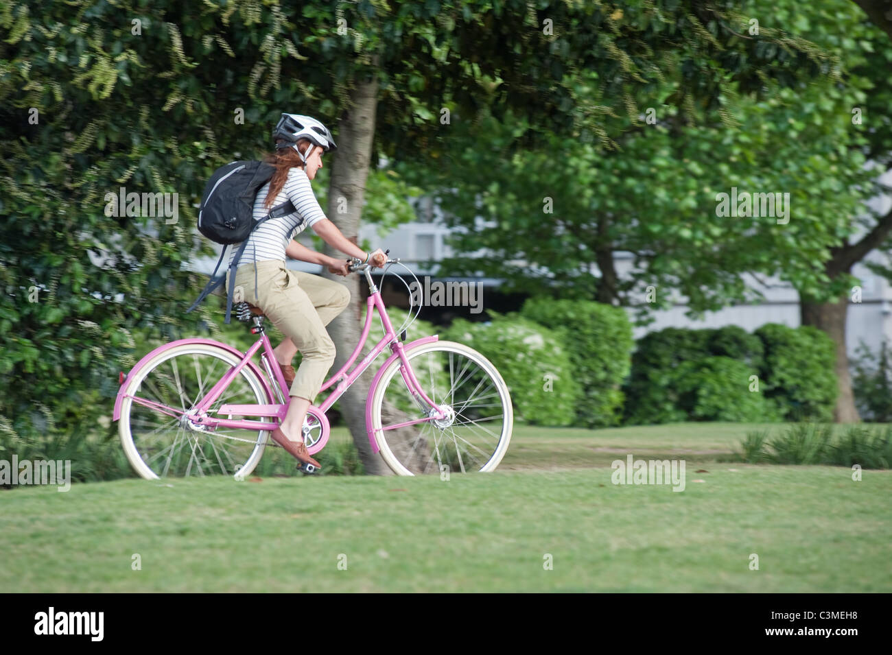 Fille sur un vélo rose par Londres park Banque D'Images