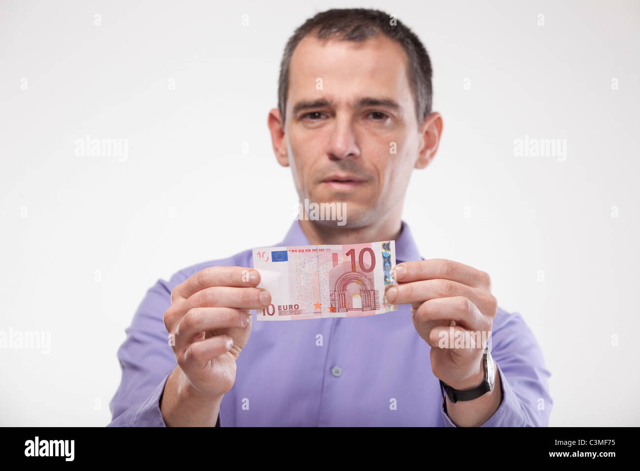 Mature man holding euro note Banque D'Images