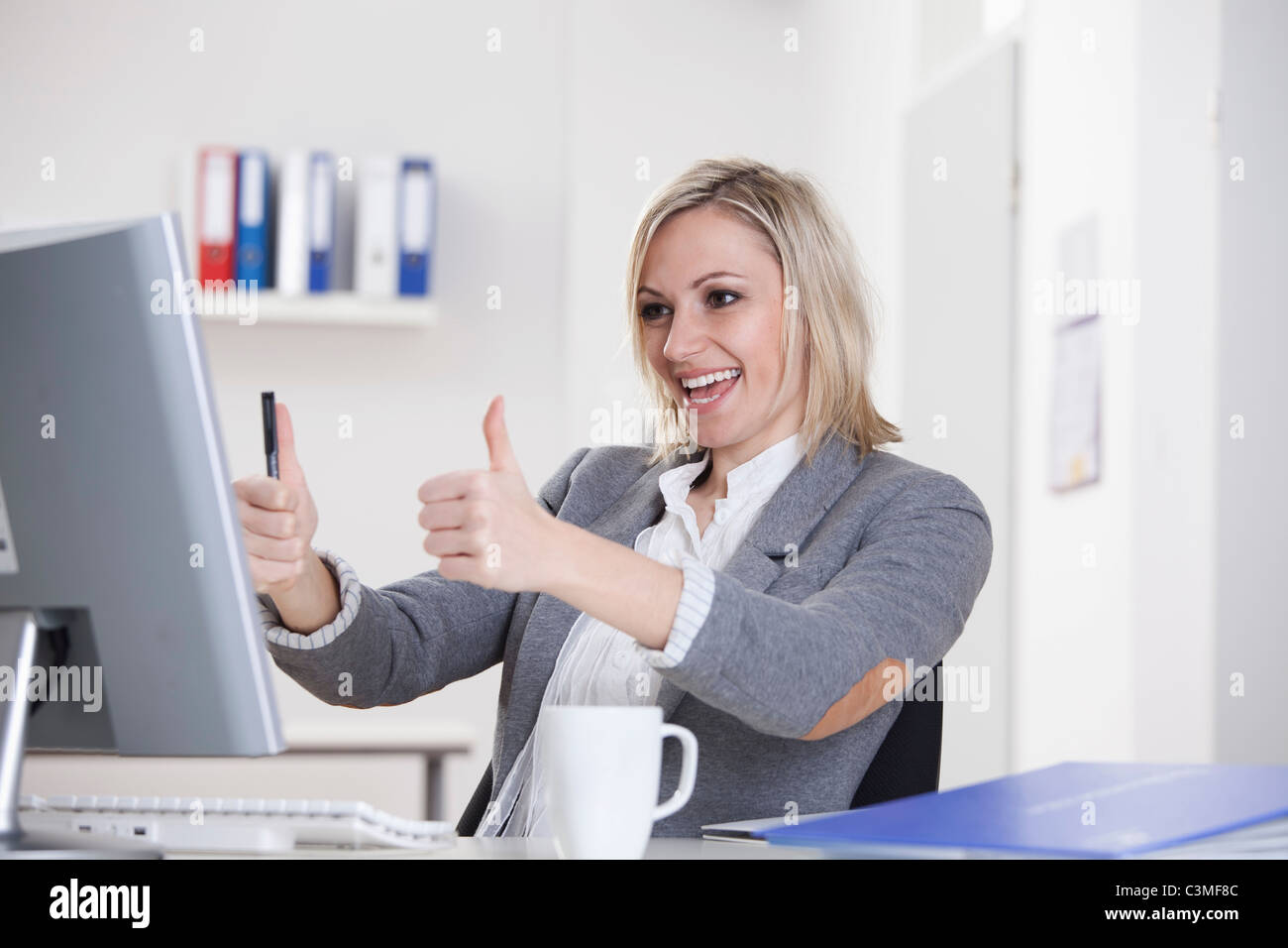 Germany, Bavaria, Munich, Businesswoman showing Thumbs up, smiling Banque D'Images
