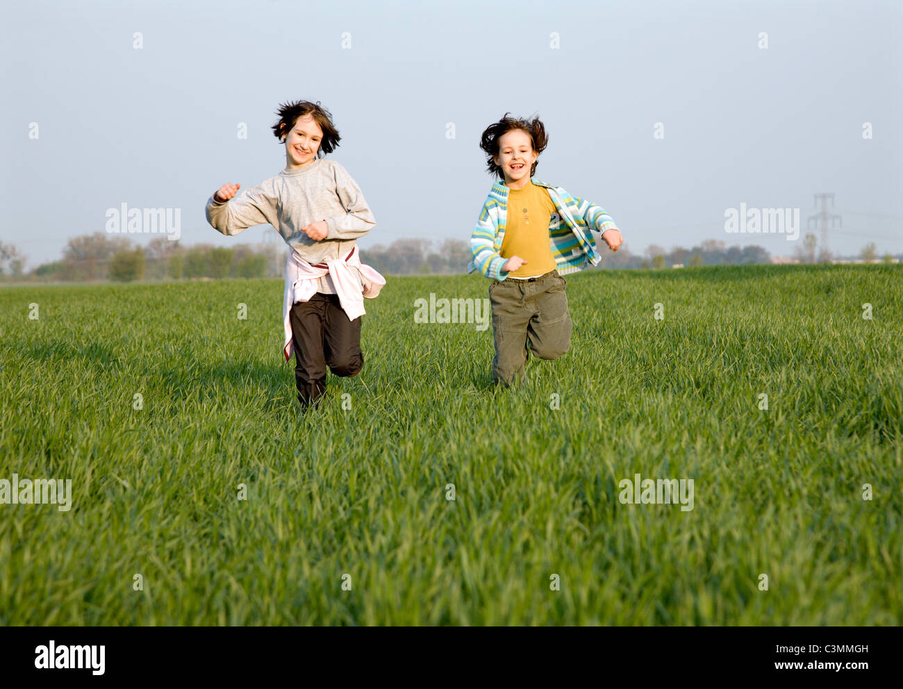 L'exécution de petite fille sur le champ de printemps Banque D'Images